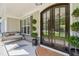 Inviting covered front porch with a swing, elegant double doors, and decorative potted plants at 143 Sallyport Ct, Raleigh, NC 27603