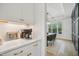 Clean white kitchen cabinetry with gold pulls, quartz countertops, and stainless appliances at 143 Sallyport Ct, Raleigh, NC 27603