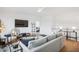 Open-concept living room featuring a sleek sofa, modern decor, and natural wood floors at 143 Sallyport Ct, Raleigh, NC 27603