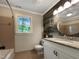 Bathroom featuring wood accent wall, granite countertop, and tub with neutral tile surround at 145 Brannigan Pl, Cary, NC 27511
