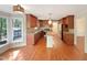 This kitchen features hardwood floors, an island, wooden cabinets and a view to the outdoors at 145 Brannigan Pl, Cary, NC 27511
