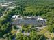 Aerial view showcasing brick building with large trees and surrounding landscape at 1535 Caraleigh Mills Ct # 104, Raleigh, NC 27603