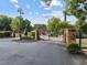 Gated entrance of property featuring brick pillars, black iron gate, and lush greenery at 1535 Caraleigh Mills Ct # 104, Raleigh, NC 27603
