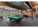 Large game room with exposed wooden beams, pool table, brick accent wall, and carpet flooring at 1535 Caraleigh Mills Ct # 104, Raleigh, NC 27603
