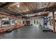 Gym area showcasing mirrors, gym equipment, brick accent wall, and exposed wood beams at 1535 Caraleigh Mills Ct # 104, Raleigh, NC 27603