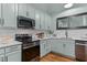 Charming kitchen featuring light blue cabinetry, stainless steel appliances, and hardwood floors at 1535 Caraleigh Mills Ct # 104, Raleigh, NC 27603