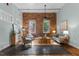 Spacious living room with exposed brick wall, large windows, and hardwood floors at 1535 Caraleigh Mills Ct # 104, Raleigh, NC 27603