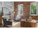 Cozy living room with exposed brick wall, large windows, and comfortable seating at 1535 Caraleigh Mills Ct # 104, Raleigh, NC 27603
