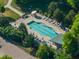 Aerial view of a community pool with lounge chairs and lush green surroundings at 1535 Caraleigh Mills Ct # 104, Raleigh, NC 27603