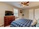 This cozy bedroom features neutral walls, a ceiling fan, and a wooden dresser with a television at 1700 W Front St # 36 D, Burlington, NC 27215