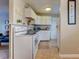 Efficient kitchen boasts white cabinets and appliances with adjoining living space at 1700 W Front St # 36 D, Burlington, NC 27215