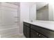 Bathroom with a tub and shower combo, quartz countertop, dark brown cabinets, and a mirror at 1817 Shady Oaks Dr, Wendell, NC 27591