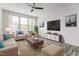 Bright living room featuring a ceiling fan, large windows, and cozy seating at 1817 Shady Oaks Dr, Wendell, NC 27591