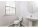 Powder room features a pedestal sink, toilet, and a window for natural lighting at 1817 Shady Oaks Dr, Wendell, NC 27591