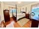 Bedroom with a four-poster bed, hardwood floors, and natural light from the window at 1829 Stewart Farm Rd, Henderson, NC 27537