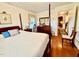 Bedroom featuring a four-poster bed, hardwood floors, and access to the hallway at 1829 Stewart Farm Rd, Henderson, NC 27537