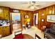 Cozy dining area with wood-paneled walls, a ceiling fan, and classic furnishings at 1829 Stewart Farm Rd, Henderson, NC 27537