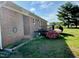 Side view of a brick house featuring a black metal patio and landscaped flower beds at 1829 Stewart Farm Rd, Henderson, NC 27537