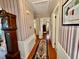 Classic hallway featuring striped wallpaper, hardwood floors, and an area rug at 1829 Stewart Farm Rd, Henderson, NC 27537