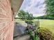 Brick patio with a black railing surrounded by trees and greenery at 1829 Stewart Farm Rd, Henderson, NC 27537