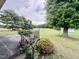 Inviting patio with black railing, plants, and a view of the expansive, green backyard at 1829 Stewart Farm Rd, Henderson, NC 27537