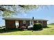 A brick ranch home featuring a back door entry and well-maintained landscaping at 1829 Stewart Farm Rd, Henderson, NC 27537
