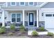 Inviting front porch with seating and stone accents that leads to a stylish front door at 1950 Menet St, Apex, NC 27502