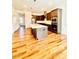 Open kitchen with stainless steel appliances, center island, hardwood floors, and adjacent living area at 1950 Menet St, Apex, NC 27502