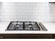 Stainless steel gas range top on an island with white subway tile backsplash at 1950 Menet St, Apex, NC 27502