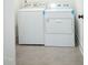 Functional laundry room featuring a side-by-side washer and dryer set and neutral tile flooring for easy maintenance at 1950 Menet St, Apex, NC 27502