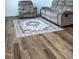 Living room with hardwood floor, comfortable armchair, couch, and a colorful rug at 1950 Menet St, Apex, NC 27502