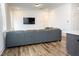 Large sectional couch in living room with a big-screen television on the wall at 1950 Menet St, Apex, NC 27502