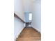 Wooden stairs with white risers and a wooden handrail leading to a bright entry way with a windowed door at 1950 Menet St, Apex, NC 27502