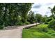 A picturesque concrete walking trail surrounded by lush trees offers a serene and scenic route for recreation at 1950 Menet St, Apex, NC 27502