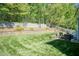 Spacious backyard featuring lush green lawn, stone retaining wall, fire pit, and patio seating for outdoor relaxation at 212 Mickleson Ridge Dr, Raleigh, NC 27603