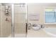 Bathroom featuring a glass shower and soaking tub with natural light at 212 Mickleson Ridge Dr, Raleigh, NC 27603