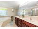 Bright bathroom featuring double sinks, soaking tub, and large mirror at 212 Mickleson Ridge Dr, Raleigh, NC 27603