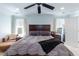 Comfortable bedroom with a large bed, ceiling fan, and two bright windows at 212 Mickleson Ridge Dr, Raleigh, NC 27603