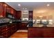 Elegant kitchen featuring dark wood cabinetry, sleek countertops, and an adjacent dining area at 212 Mickleson Ridge Dr, Raleigh, NC 27603