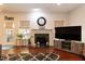 Bright living room featuring fireplace, hardwood floors, and a large television set at 212 Mickleson Ridge Dr, Raleigh, NC 27603