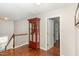 Upstairs hallway showcasing hardwood floors, open doors, and a decorative display cabinet at 2317 Rainy Lake St, Wake Forest, NC 27587