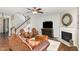 Comfortable living room with a fireplace, staircase, dark wood floors, and cozy seating area at 2317 Rainy Lake St, Wake Forest, NC 27587