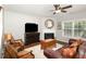Cozy living room featuring a fireplace, dark wood floors, ceiling fan, and comfortable seating arrangement at 2317 Rainy Lake St, Wake Forest, NC 27587