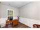 Bright office with a classic wooden desk, neutral walls with white chair rail, and hardwood floors at 2317 Rainy Lake St, Wake Forest, NC 27587