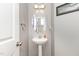 Stylish powder room with a pedestal sink, oval mirror, and neutral color palette at 2317 Rainy Lake St, Wake Forest, NC 27587
