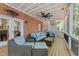 Spacious covered back porch with brick wall, ceiling fan, and comfortable wicker furniture with blue cushions at 2520 Ashley Ct, Raleigh, NC 27607