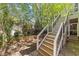 A fenced-in backyard with mature trees and a staircase leading to an elevated patio at 2520 Ashley Ct, Raleigh, NC 27607