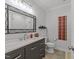Stylish bathroom featuring a dark vanity with marble countertop, modern lighting, and decorative mirror at 2520 Ashley Ct, Raleigh, NC 27607