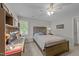 Well-lit bedroom with a ceiling fan, a workstation area, and a comfortable bed dressed with a striped cover at 2520 Ashley Ct, Raleigh, NC 27607