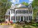 Charming two-story home featuring white siding, black shutters, and a well-manicured front yard and mature trees at 2520 Ashley Ct, Raleigh, NC 27607